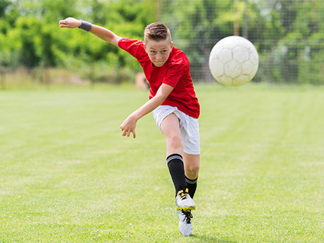 Kid kicking soccer clearance ball